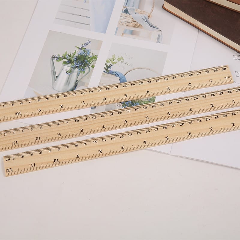 Three wooden rulers showing inch and centimeter measurements.