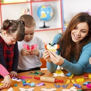 Kids crafting with colorful wooden butterfly cutouts