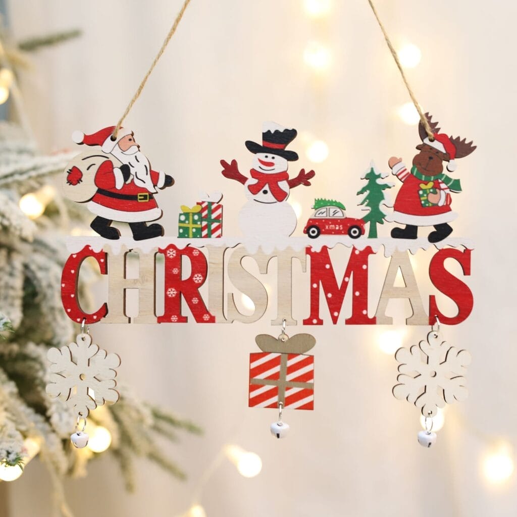 Wooden Christmas decoration with Santa, a snowman, and a reindeer above the word "CHRISTMAS," hanging on a string with snowflakes, a present, and tree lights in the background.
