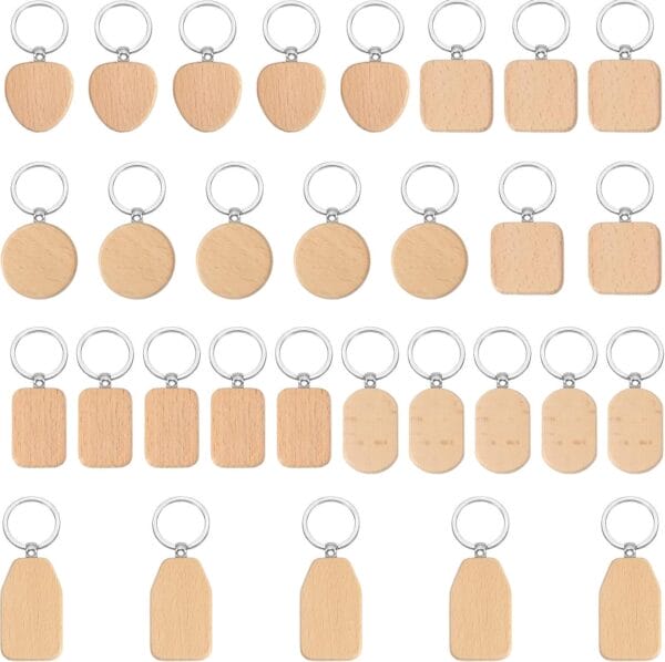 A set of 25 blank wooden keychains in various shapes—shield, heart, circle, square, rectangle, and house—each with a silver key ring, arranged in five rows.