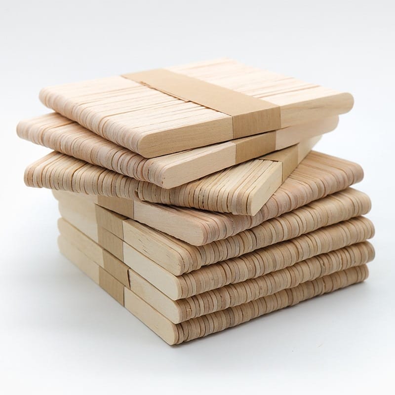 Four stacks of plain Wood Sticks For Crafts are bundled together with rubber bands against a white background.