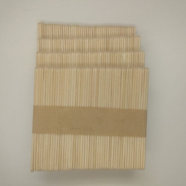 A bundle of Wood Sticks For Crafts stacked neatly and held together by a brown paper band, placed on a plain white background.