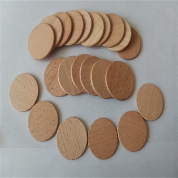 A group of flat, round beech wood coins arranged in two stacks and one loose row on a white surface.