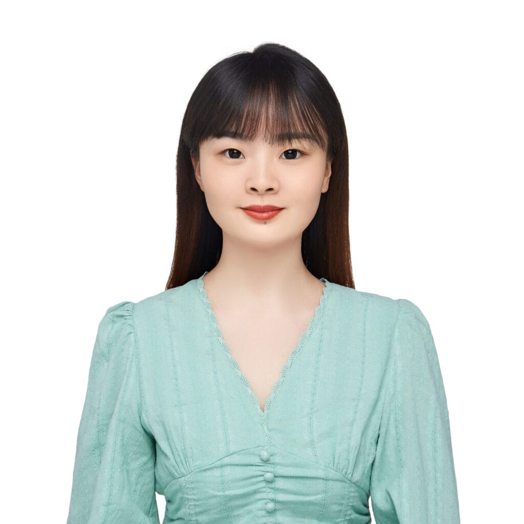 A woman with straight dark hair and bangs, wearing a light green blouse, is facing the camera against a white background.