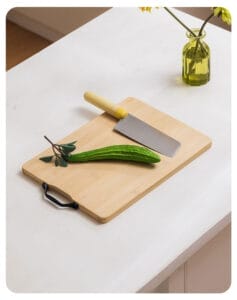 Custom Bamboo Cutting Board: Eco-friendly wooden cutting board with black handle, perfect for kitchen use. A knife and zucchini are displayed on the board.