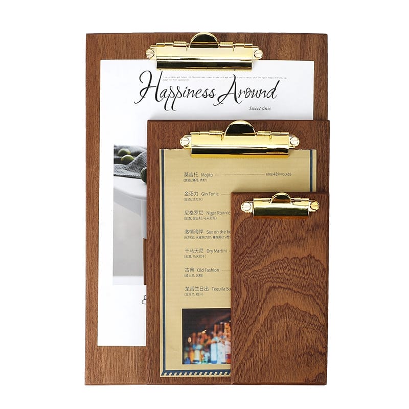 Three wooden clipboards of different sizes with gold clips, each holding a sheet of paper with text and images in various languages.