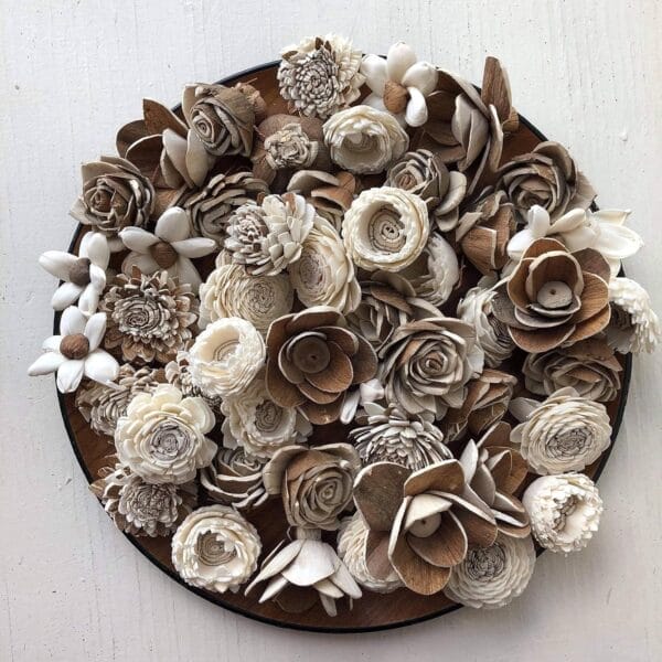 A circular arrangement of intricately crafted, neutral-toned Sola Wood Flowers is displayed against a white background.