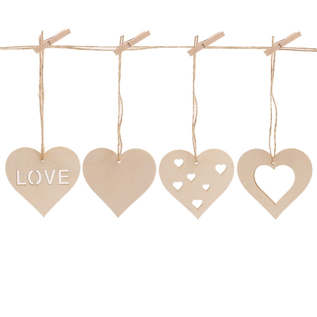 Four wooden heart-shaped ornaments hang from twine with clothespins. The hearts feature cut-out designs, including the word "LOVE" and small heart shapes.