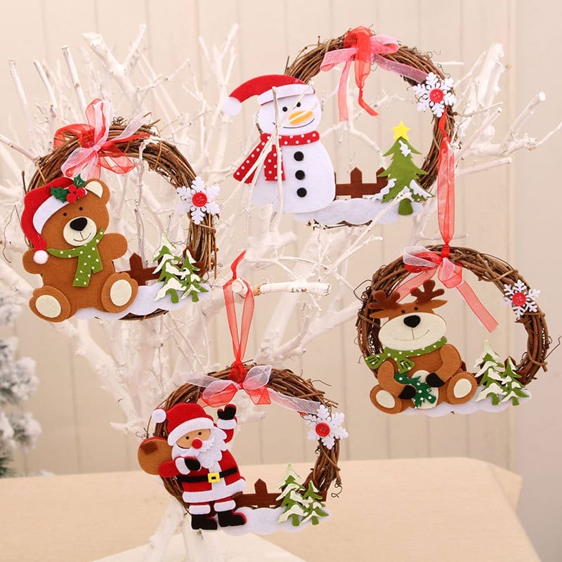 A white tree displays five Christmas wood wreath ornaments featuring felt figures—a snowman, a bear, a reindeer, and Santa Claus—each adorned with ribbons and festive details.