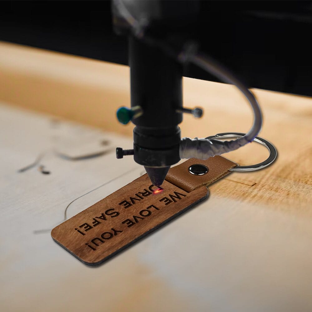Custom laser-cut wooden keychain being engraved. Wholesale wooden keychains available.