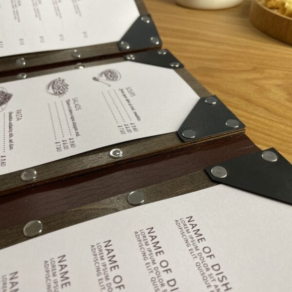 Close-up of elegant, wooden, foldable restaurant menu covers with prices. Wholesale menu.