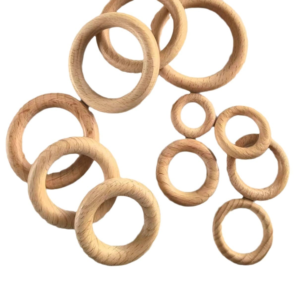 Several beech wood rings of various sizes are scattered on a white background, perfect for Wooden ring craft supplies and DIY projects.
