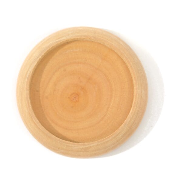 A round, flat solid wood needle base with a slightly raised edge, showing natural wood grain patterns, photographed against a white background.