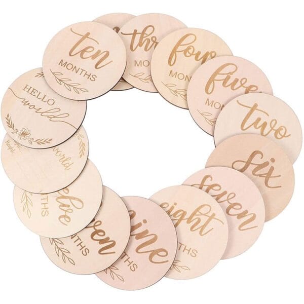 A set of twelve round craft circle wood milestone discs, each labeled with a number of months or a phrase, arranged in a charming circle.