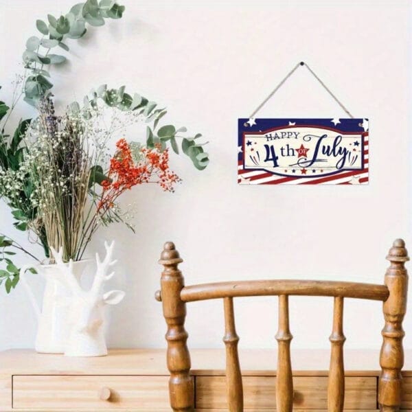 Happy 4th of July wooden sign hanging on wall above wooden desk with flowers