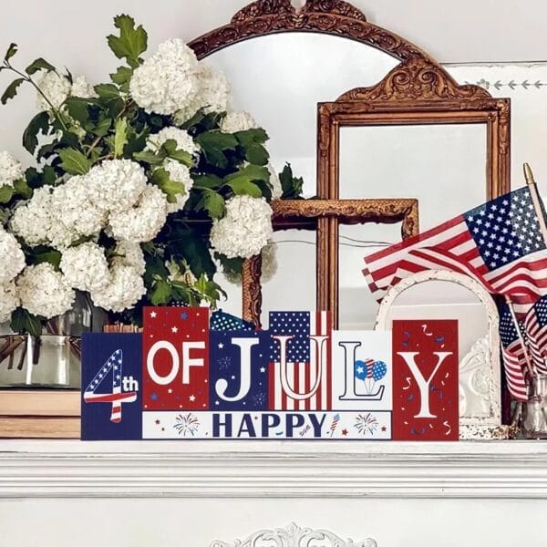 Patriotic "4th of July Happy" wooden block sign with American flags and hydrangeas.