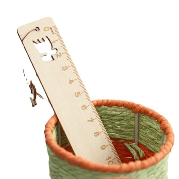 An engraved ruler with cutout shapes is placed in a woven green and orange basket, making it a charming choice for custom gifts.