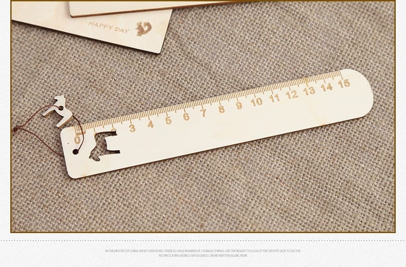 A wooden ruler with a horse-shaped cutout at one end, placed on a textured beige fabric surface next to a paper card—ideal for engraved rulers or custom gifts.