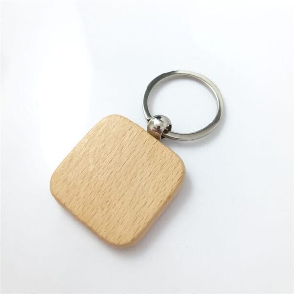 Square laser cut wood keychain with rounded edges, made from sustainable beech wood and attached to a metal key ring, placed on a white surface. Ideal for wholesale orders.
