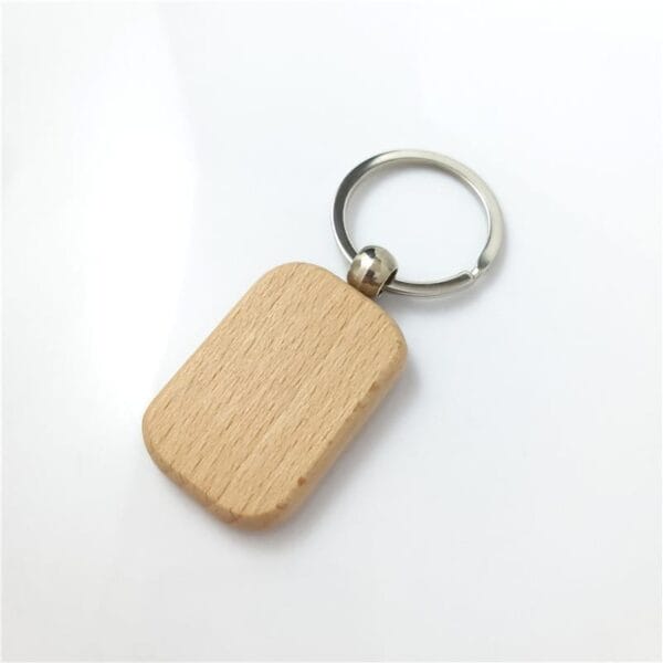 A rectangular sustainable beech wood keychain with rounded edges, crafted by a keychain manufacturer and attached to a metal keyring, placed on a white background.