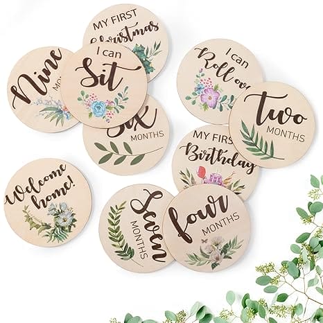 Eco-friendly piece wood milestone discs with floral designs. Nine, two, four, six, seven months, first birthday, first Christmas, welcome home, I can sit, I can roll over.
