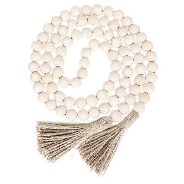 A string of round, unfinished wood beads with two jute tassels at the ends, arranged in a spiral.