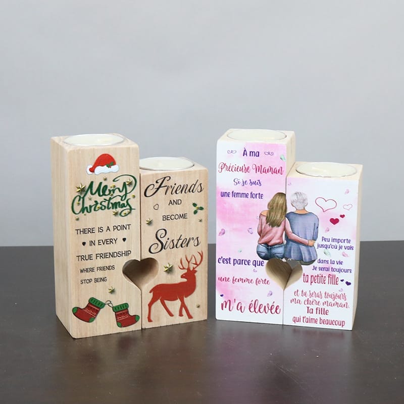 Three decorative wood candle holders with holiday and sentimental messages in English and French, featuring heart cutouts and illustrated designs.