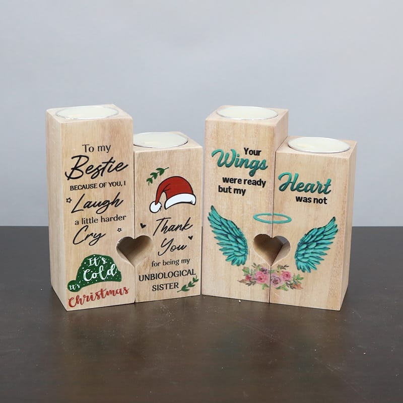 Two sets of wooden candle holders, including heart-shaped candle holders with holiday and friendship themes, and a wood candle holder featuring angel wings and a remembrance quote. Ideal for gifts or wholesale orders.