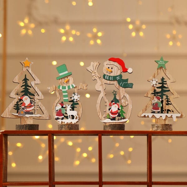Four wood Christmas decorations featuring trees, snowmen, and Santa Claus are displayed on a ledge with warm string lights glowing softly in the blurred background.
