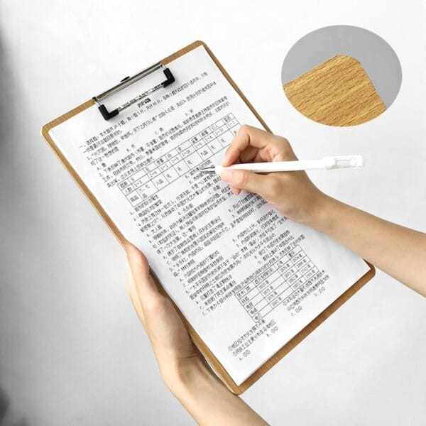 Person filling out a custom wood clipboard with a pen. Bulk A4 menu holders.