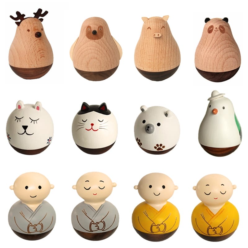 Twelve wooden figurines, crafted in the style of wood crafts, are shaped and painted as various animals and monks, arranged in three rows against a white background.