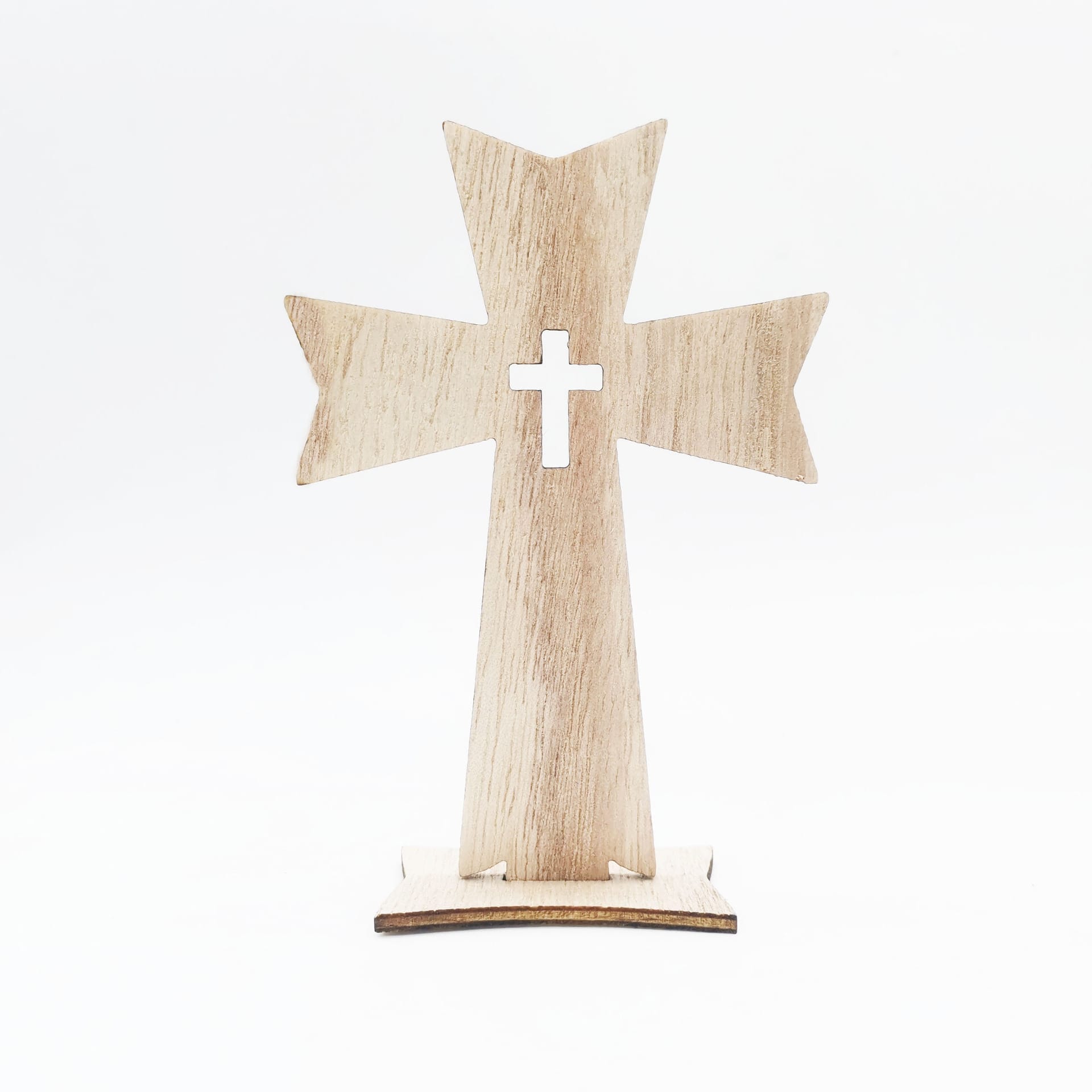A handmade decorative wood cross with pointed ends stands upright on a flat base against a plain white background. A smaller cross is cut out in the center, making it a unique wood cross craft item.