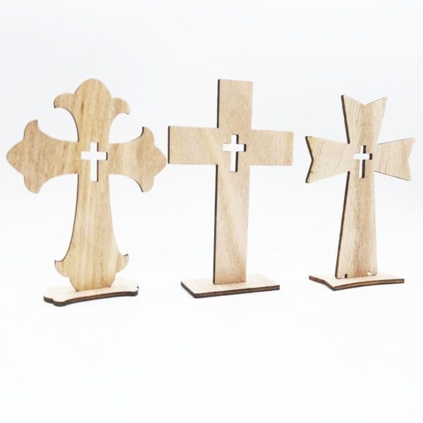 Three wooden crosses with different shapes and cutout centers are standing upright on a white background, perfect as a wood cross craft or part of a handmade decorative set from a wholesale manufacturer.