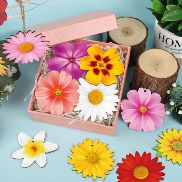 A pink gift box filled with colorful artificial daisy flowers sits on a blue surface, surrounded by wood flowers, plants, Wooden Hanging Decorations, and wood slices.