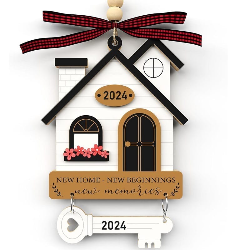 A decorative wood gift house ornament with "2024" and "New Home - New Beginnings - New Memories" text, featuring a white key labeled "2024" and a red plaid ribbon on top.