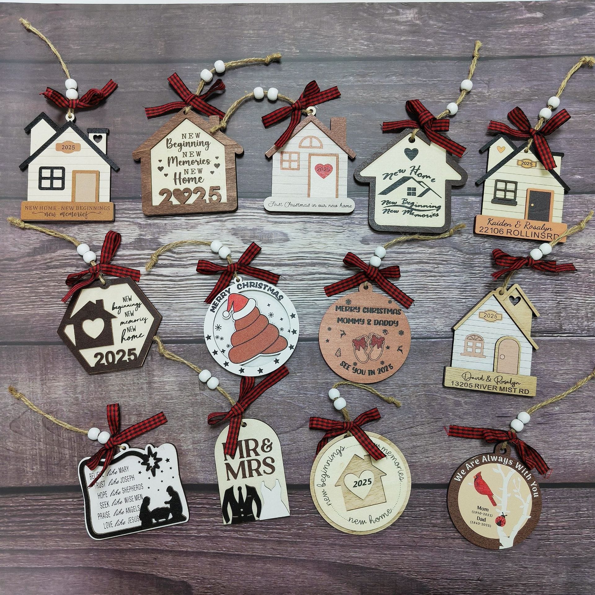 A collection of house-shaped and round Christmas Wooden Ornaments with personalized messages, red plaid bows, and twine, arranged on a wooden surface.