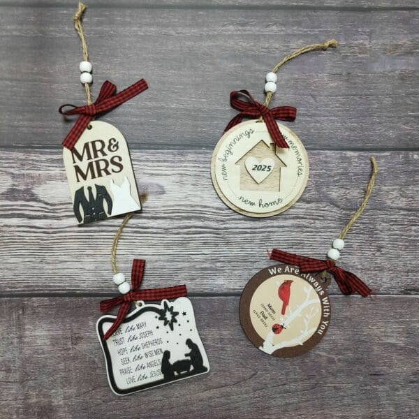 Four wooden Christmas ornaments with various designs and text, each featuring twine loops and red plaid bows, displayed on a wooden surface—perfect as House Pendant Decorations from a trusted Christmas Wooden Ornaments maker.