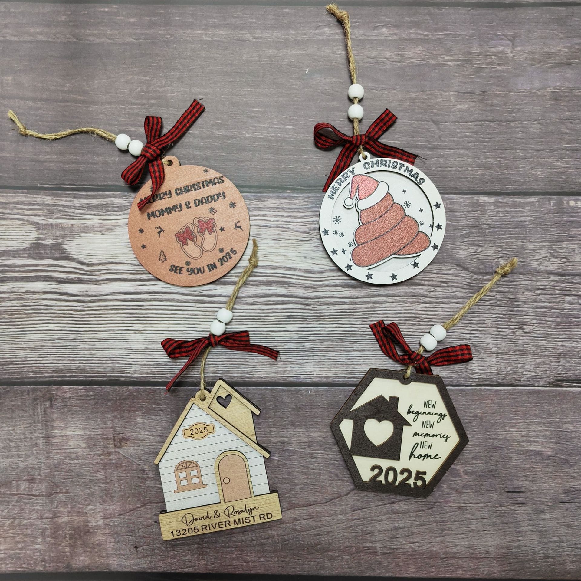 Four wooden tree ornaments with unique designs—a Santa, poop emoji, house pendant decoration, and a hexagon with a heart—each feature red plaid ribbon and twine for hanging. Perfect from a wood gifts manufacturer.