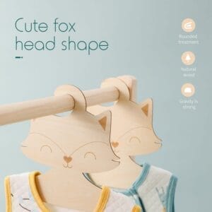 Two adorable wood hangers, shaped like fox faces, hold children’s garments on a wooden rod; accompanying text highlights their charming features.