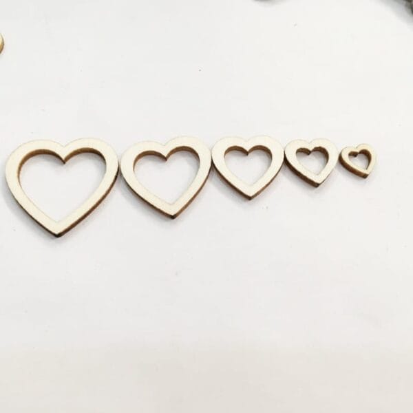 Five eco-friendly wooden heart-shaped cutouts are arranged in a row from largest to smallest on a white background, perfect for crafts or cross-border wood heart projects.