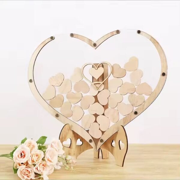 Heart-shaped heart wooden wedding guest book holder filled with small wooden hearts. Wholesale wedding decor.