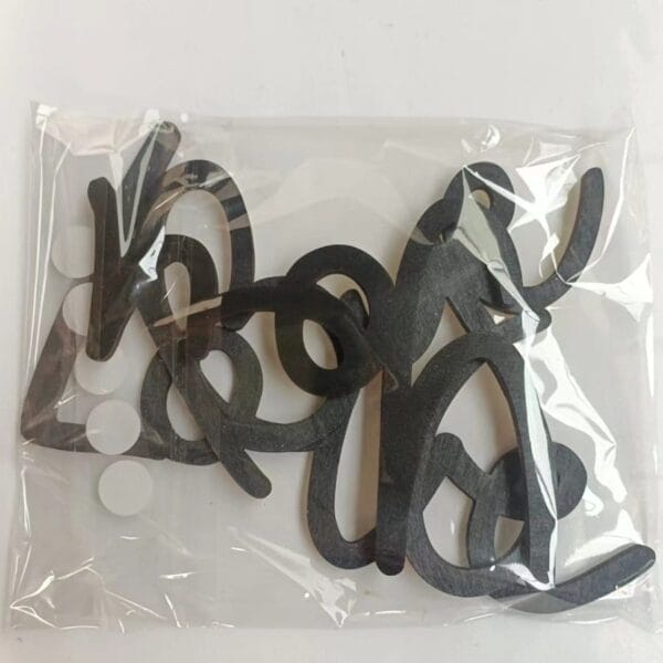 A clear plastic bag containing several black foam cutouts with curved shapes, perfect for Halloween decor, placed on a white surface.