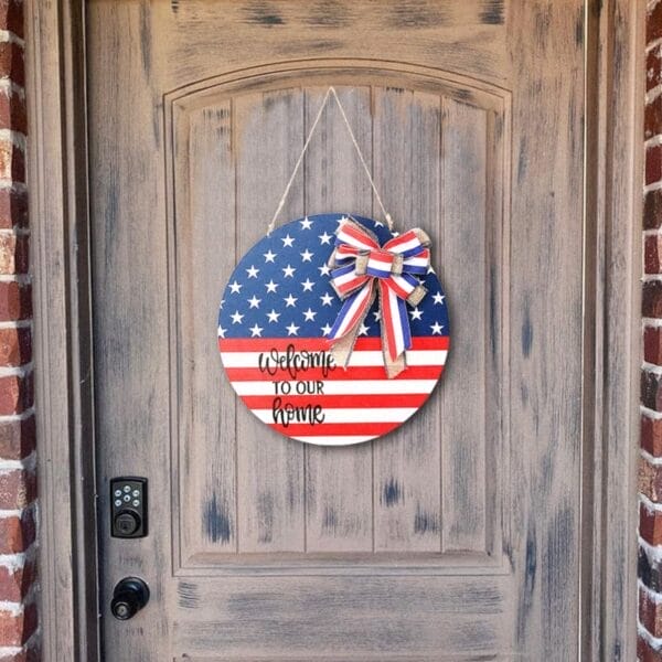 A round Wood Plaque with an American flag design and a bow hangs on the door, displaying "Welcome to our home"—a perfect Wooden Door Hanger for Independence Day.
