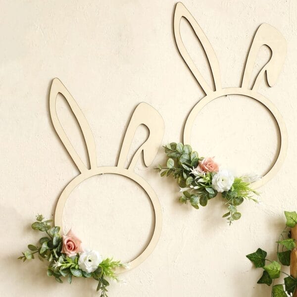 Two wooden rabbit shape wreath frames decorated with artificial greenery and pastel blooms create a charming artificial flower hanging, perfect as a wood wall decoration on any light-colored wall.