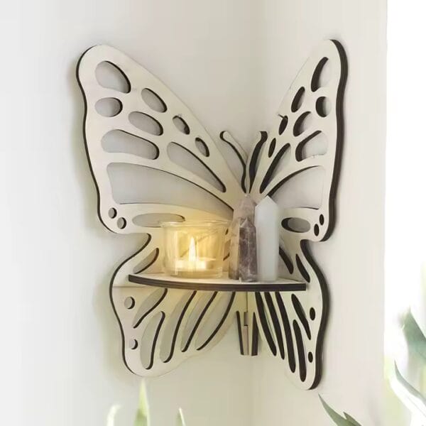 A butterfly-shaped wooden wall hanging decor shelf holds a lit candle, a crystal, and a white cylinder in a well-lit room.
