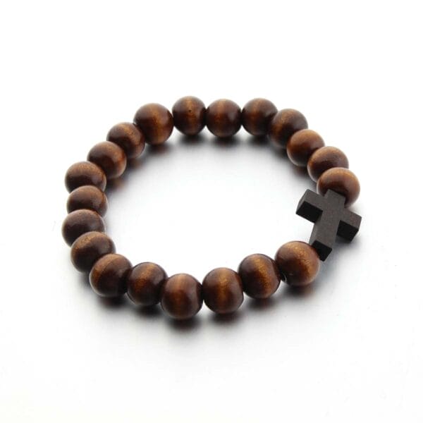 A wooden bead bracelet featuring a dark wooden cross, elegantly displayed on a white background.