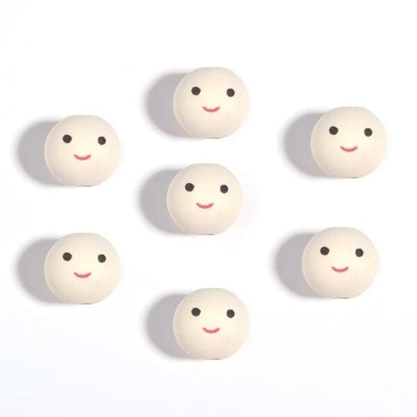 Seven round white objects with simple black eyes and red smiling mouths are arranged in a grid pattern on a white background.