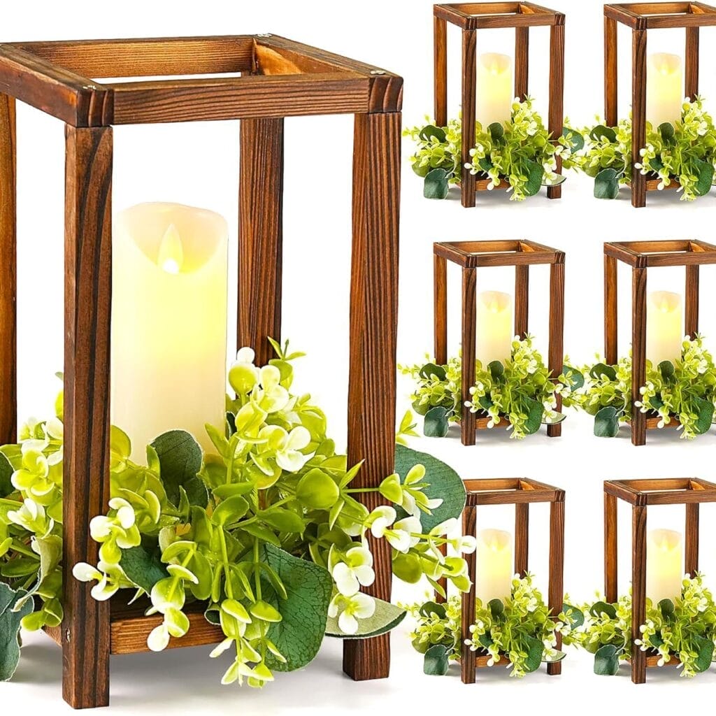 A wooden candle stand lantern-style holder with artificial greenery and a white candle inside, displayed in multiple identical sets against a white background.