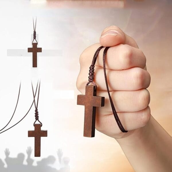 A hand holds a laser cut wooden cross pendant on a brown cord, with the cross shown in different positions on the left side of the image.