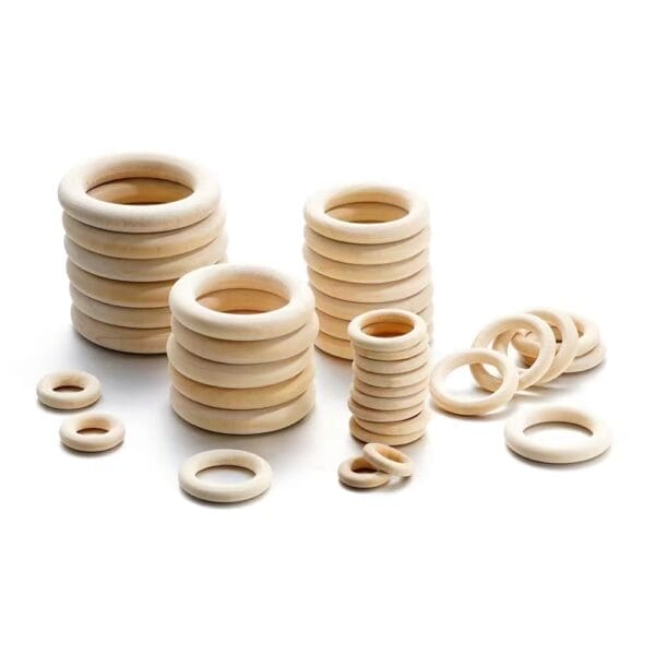 A set of eco-friendly wooden curtain rings in various sizes arranged in stacks and scattered on a white background, perfect for stylish home decor accents.